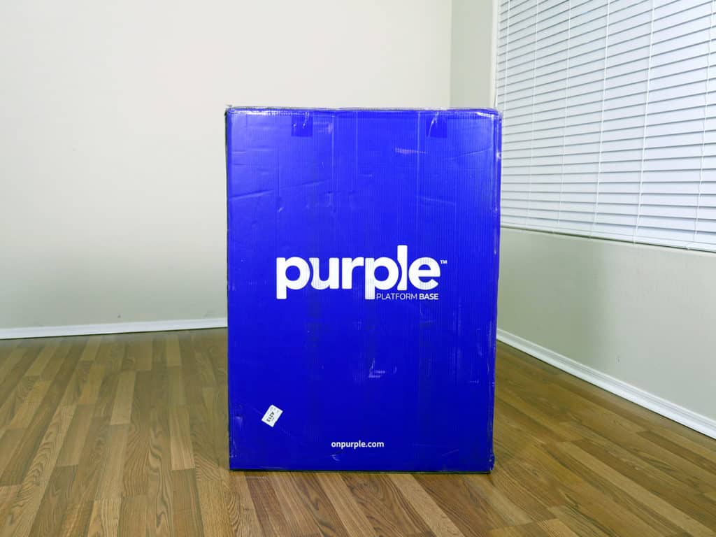 紫色的台子床在盒子里。盒子实际上是紫色的，相机让它看起来更蓝。